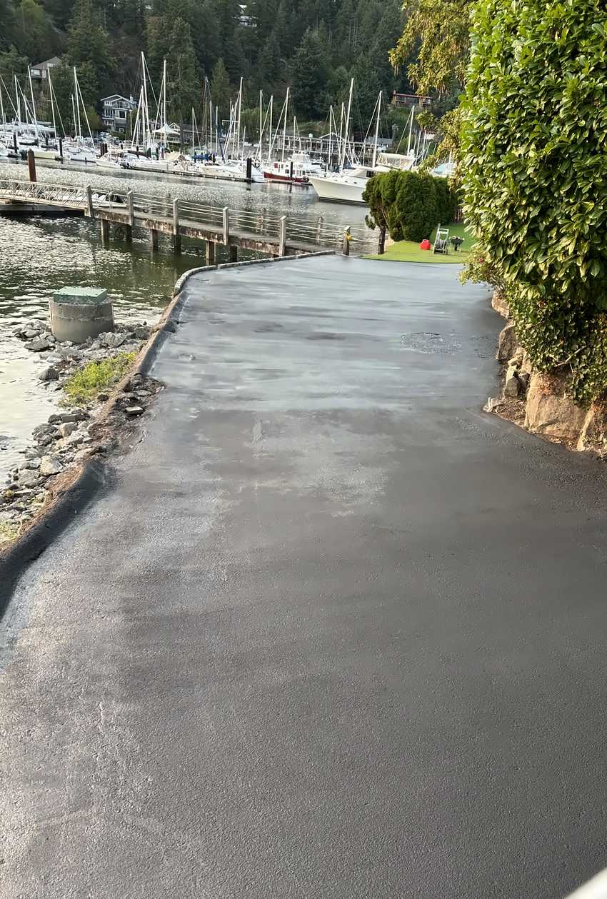 The same stretch sealed black to the seawall edge